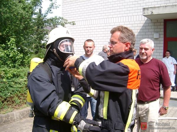 Bild 6 von 20 Brand&uuml;bungscontainer: Der richtige Sitz der Schutzkleidung wird vom Ausbilder &uuml;berpr&uuml;ft und der Lungenautomat wird angeschlossen.
